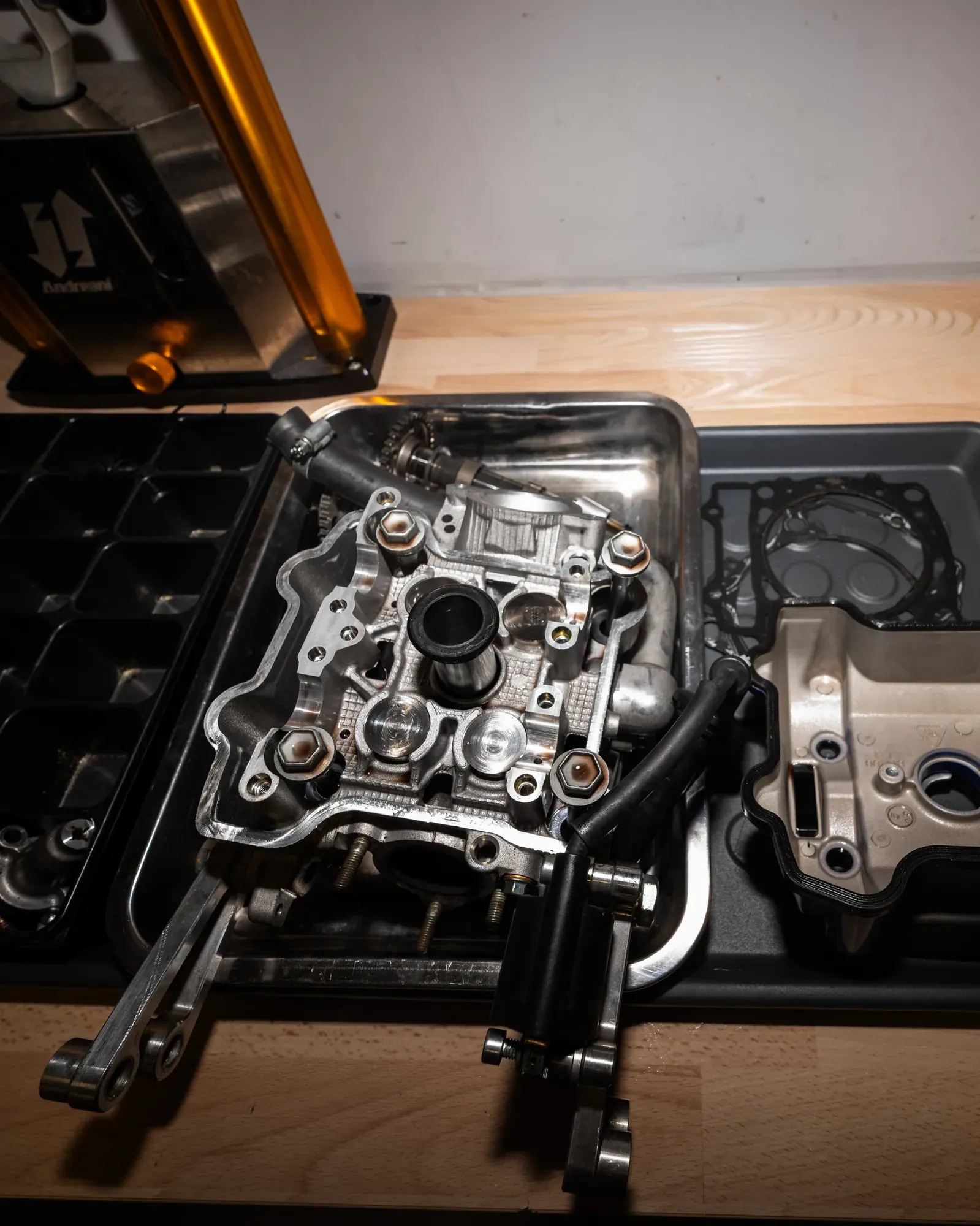 Culata del motor de una Moto3 desmontada sobre la bandeja de trabajo