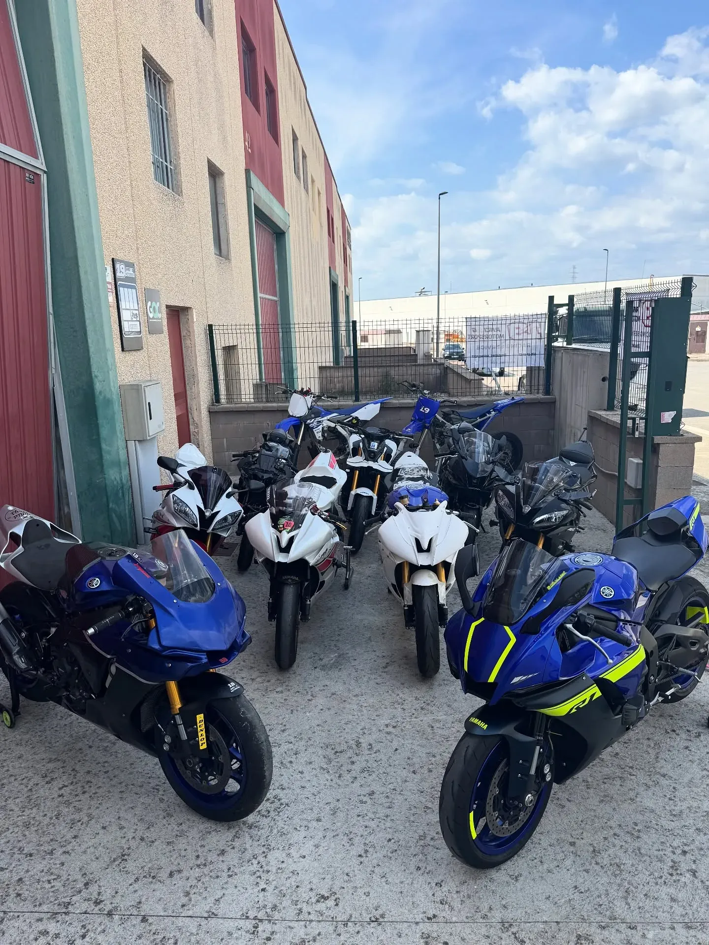 Grupo de motos deportivas Yamaha aparcadas frente a la puerta del taller